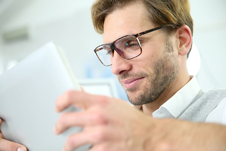 A man reads wearing glasses